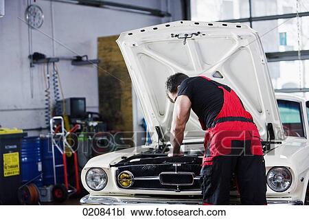rear view of mechanic repairing car engine View Large Photo Image Stock Image - rear view of mechanic repairing car engine. Fotosearch