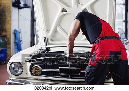 rear view of mechanic repairing car engine View Large Photo Image Stock Image - rear view of mechanic repairing car engine. Fotosearch