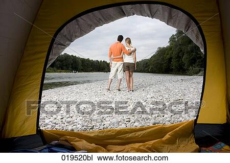 rear view of young couple on riverbank seen through tent View Large Photo Image Stock Image - rear view of young couple on riverbank seen through tent. Fotosearch
