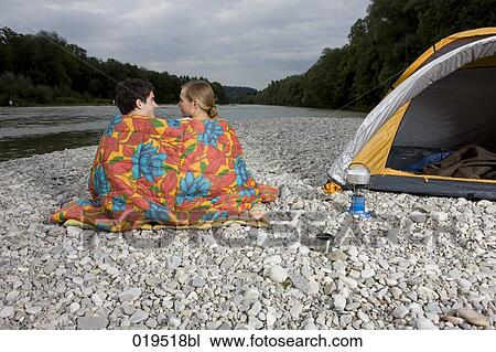 rear view of young couple sitting on riverbank near tent View Large Photo Image Stock Image - rear view of young couple sitting on riverbank near tent. Fotosearch