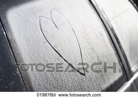 Stock Image - still life of heart drawn in frost on car window. Fotosearch
