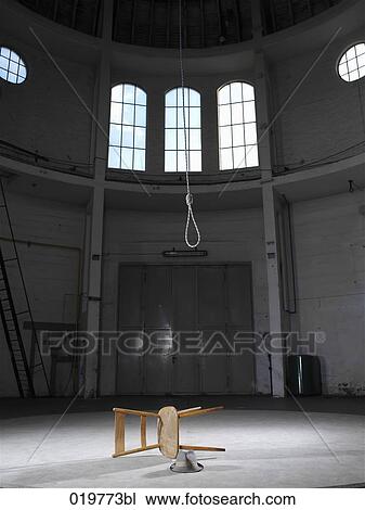 Stock Image - still life of overthrown chair hat and rope in empty building. Fotosearch