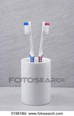 Stock Image - two toothbrushes back to back. Fotosearch