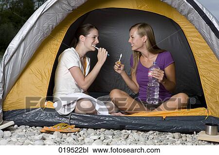 two young women sitting in tent brushing their teeth View Large Photo Image Stock Image - two young women sitting in tent brushing their teeth. Fotosearch