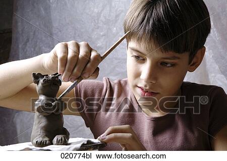 young boy forming little sculpture out of clay View Large Photo Image Stock Image - young boy forming little sculpture out of clay. Fotosearch