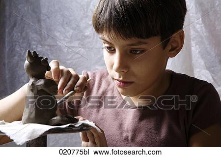 young boy forming little sculpture out of clay View Large Photo Image Stock Image - young boy forming little sculpture out of clay. Fotosearch