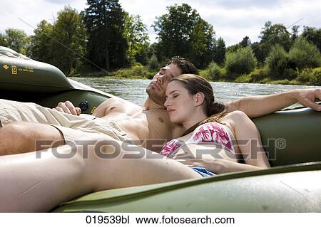 young couple dozing on rubber boat by river View Large Photo Image Stock Image - young couple dozing on rubber boat by river. Fotosearch