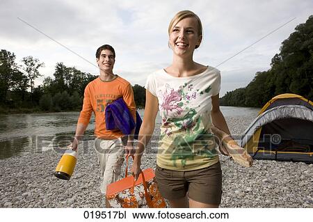 young couple riverbank carrying picnic basket View Large Photo Image Stock Image - young couple riverbank carrying picnic basket. Fotosearch