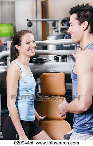 young couple talking to each other in gym View Large Photo Image Stock Image - young couple talking to each other in gym. Fotosearch