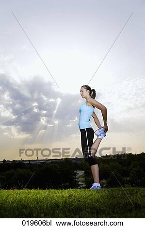 young jogger doing stretching exercises in park View Large Photo Image Stock Image - young jogger doing stretching exercises in park. Fotosearch