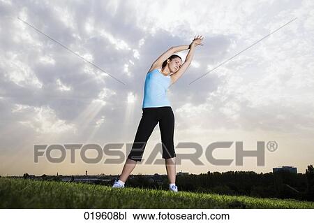 young jogger doing stretching exercises in park View Large Photo Image Stock Image - young jogger doing stretching exercises in park. Fotosearch