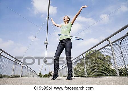 young woman doing hula hoop on bridge View Large Photo Image Stock Image - young woman doing hula hoop on bridge. Fotosearch