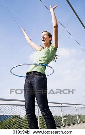 young woman doing hula hoop on bridge View Large Photo Image Stock Image - young woman doing hula hoop on bridge. Fotosearch