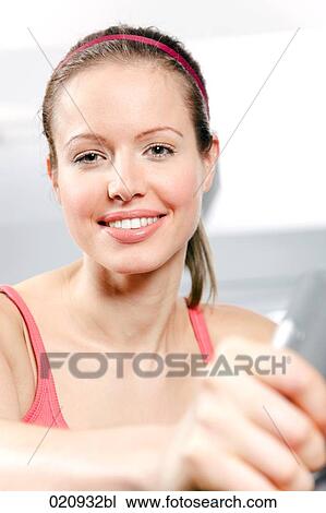 young woman exercising with stationary bicyle in gym View Large Photo Image Stock Image - young woman exercising with stationary bicyle in gym. Fotosearch