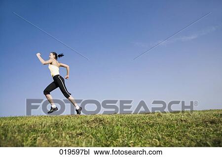 Stock Image - young woman jogging in park. Fotosearch