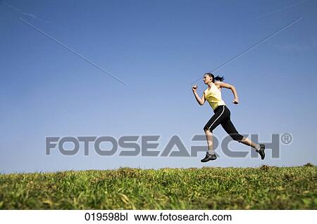 Stock Image - young woman jogging in park. Fotosearch