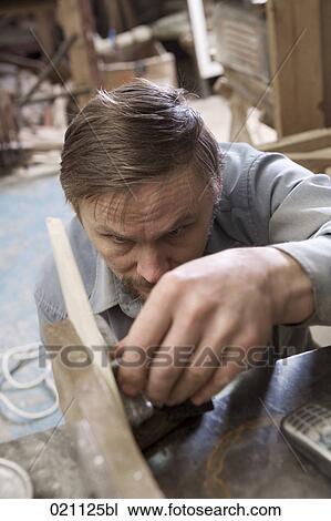 Stock Image - carpenter fixing piece of wood with hand-vice. Fotosearch