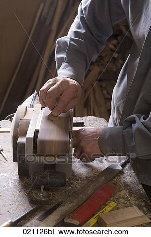 Stock Image - carpenter grinding piece of wood. Fotosearch