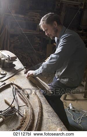carpenter sawing plank of wood View Large Photo Image Stock Image - carpenter sawing plank of wood. Fotosearch