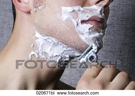 Stock Image - close-up of young man shaving. Fotosearch