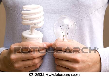 close-up of young woman holding conventional and low energy light bulb View Large Photo Image Stock Image - close-up of young woman holding conventional and low energy light bulb. Fotosearch