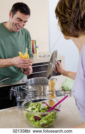 couple cooking spaghetti together in kitchen View Large Photo Image Stock Image - couple cooking spaghetti together in kitchen. Fotosearch
