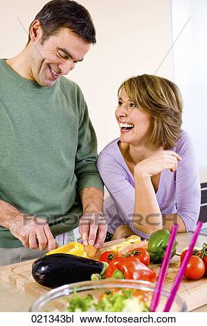 couple cooking together in kitchen man cutting vegetables View Large Photo Image Stock Image - couple cooking together in kitchen man cutting vegetables. Fotosearch
