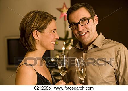 couple raising their glasses on christmas eve View Large Photo Image Stock Image - couple raising their glasses on christmas eve. Fotosearch