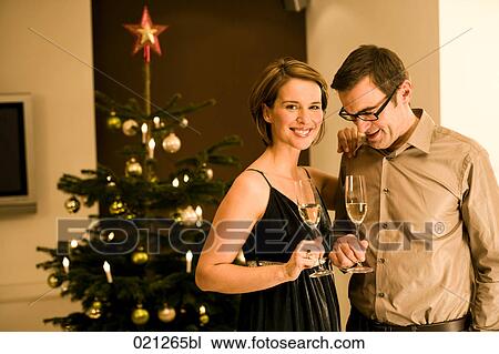 couple raising their glasses on christmas eve View Large Photo Image Stock Image - couple raising their glasses on christmas eve. Fotosearch