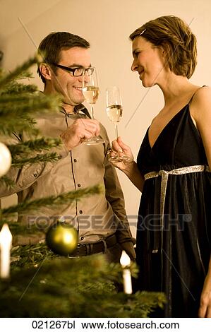 couple raising their glasses on christmas eve View Large Photo Image Stock Image - couple raising their glasses on christmas eve. Fotosearch