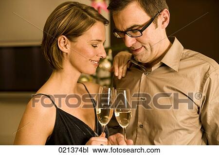couple raising their glasses on christmas eve View Large Photo Image Stock Image - couple raising their glasses on christmas eve. Fotosearch