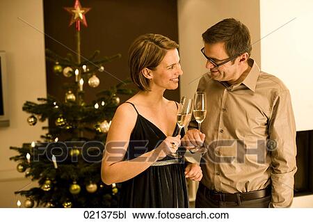 couple raising their glasses on christmas eve View Large Photo Image Stock Image - couple raising their glasses on christmas eve. Fotosearch