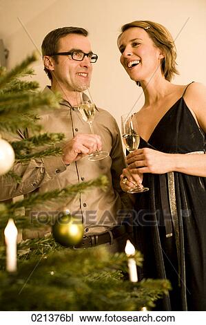 couple raising their glasses on christmas eve View Large Photo Image Stock Image - couple raising their glasses on christmas eve. Fotosearch