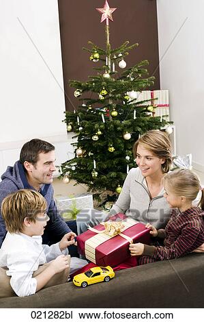 Stock Image - family exchanging presents on christmas morning. Fotosearch