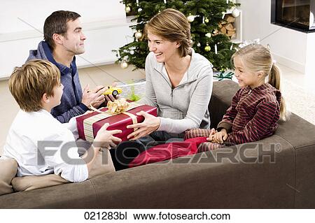 family exchanging presents on christmas morning View Large Photo Image Stock Image - family exchanging presents on christmas morning. Fotosearch