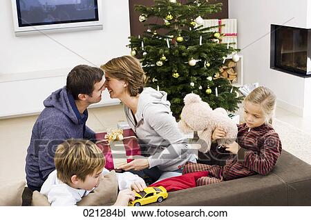 family exchanging presents on christmas morning View Large Photo Image Stock Image - family exchanging presents on christmas morning. Fotosearch