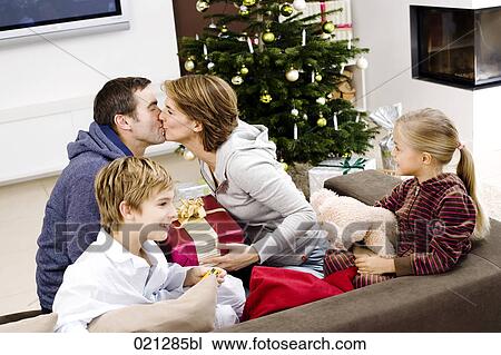 family exchanging presents on christmas morning View Large Photo Image Stock Image - family exchanging presents on christmas morning. Fotosearch