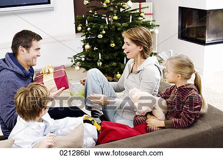 family exchanging presents on christmas morning View Large Photo Image Stock Image - family exchanging presents on christmas morning. Fotosearch