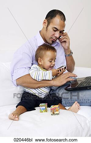 father on sofa talking on mobile phone and playing with little son View Large Photo Image Stock Image - father on sofa talking on mobile phone and playing with little son. Fotosearch