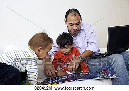 Stock Image - father on sofa with laptop computer playing with his two little sons. Fotosearch