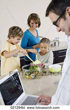 father working with laptop computer while mother and children are preparing meal View Large Photo Image Stock Image - father working with laptop computer while mother and children are preparing meal. Fotosearch