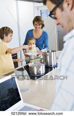 father working with laptop computer while mother and children are preparing meal View Large Photo Image Stock Image - father working with laptop computer while mother and children are preparing meal. Fotosearch