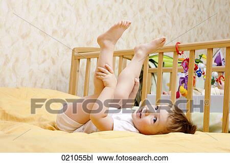 full body portrait of young boy lying on bed with legs in the air View Large Photo Image Stock Image - full body portrait of young boy lying on bed with legs in the air. Fotosearch