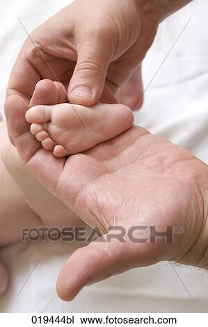 man holding tiny foot of baby View Large Photo Image Stock Image - man holding tiny foot of baby. Fotosearch