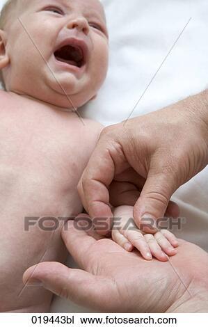 man holding tiny hand of crying baby View Large Photo Image Stock Image - man holding tiny hand of crying baby. Fotosearch