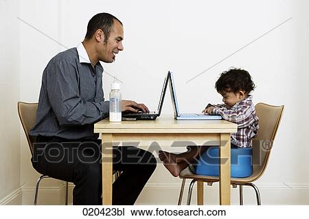man working from home sitting at table with little son View Large Photo Image Stock Image - man working from home sitting at table with little son. Fotosearch
