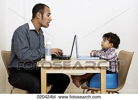 man working from home sitting at table with little son View Large Photo Image Stock Image - man working from home sitting at table with little son. Fotosearch