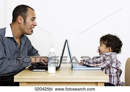 man working from home sitting at table with little son View Large Photo Image Stock Image - man working from home sitting at table with little son. Fotosearch