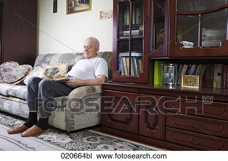 mature man sitting at home alone reading book View Large Photo Image Stock Image - mature man sitting at home alone reading book. Fotosearch