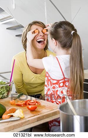mother and daughter having fun with carrot slices in kitchen View Large Photo Image Stock Image - mother and daughter having fun with carrot slices in kitchen. Fotosearch